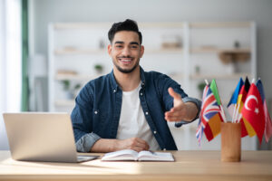 illsutration cours de langue: jeun homme travaille sur bureau avec multiple drapeaux